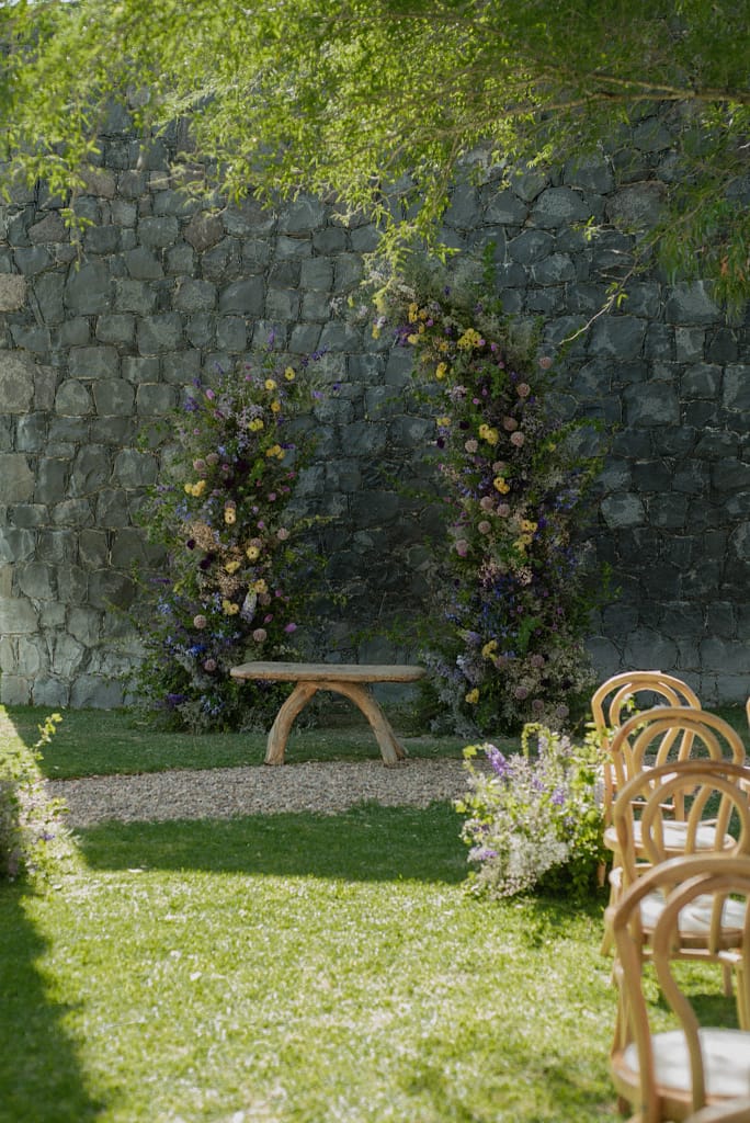 Romantic garden-style wedding flowers featuring mauve, blush, plum, and buttery yellow blooms styled by a wedding florist in San Miguel de Allende, Mexico. The bouquet and floral centerpiece include lisianthus, ranunculus, and delicate filler flowers, perfect for an elegant destination wedding. Captured at Casa Adela with soft candlelight and seasonal fruits, the floral design blends old-world charm with modern romance.